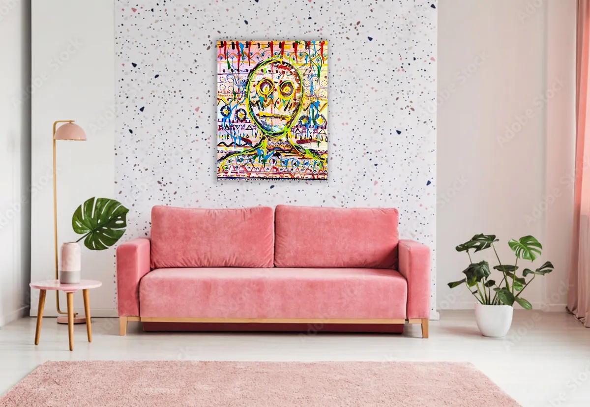 Hanging above a pink sofa on a speckled white wall